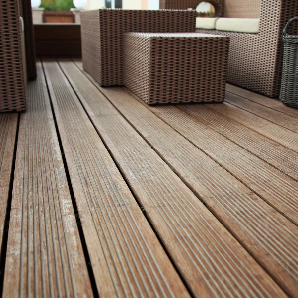 A close-up of a patio in Dubai features warm brown wood-look plank flooring with a grooved texture.
