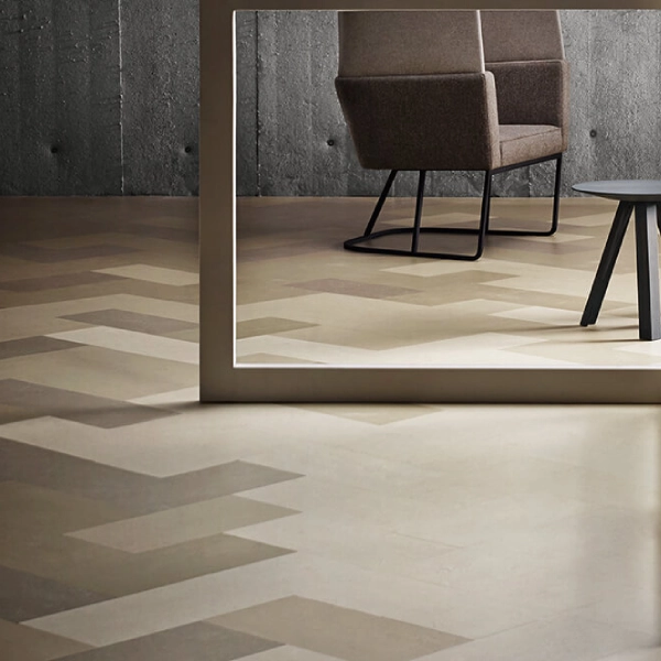 A contemporary interior space featuring a light and dark beige herringbone pattern linoleum floor, a minimalist frame or partition in the foreground.